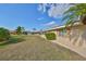 Home's backyard featuring a well-manicured lawn and mature landscaping at 701 Baltusrol Way, Sun City Center, FL 33573