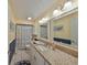 Bathroom with double sink vanity, granite countertops, and updated lighting at 701 Baltusrol Way, Sun City Center, FL 33573