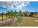 Charming home with landscaped front yard, featuring palm trees and decorative rock gardens under a sunny sky at 701 Baltusrol Way, Sun City Center, FL 33573
