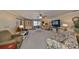 Spacious living room featuring carpet floor, ceiling fan, light color walls, and media center at 701 Baltusrol Way, Sun City Center, FL 33573