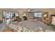 Living room with carpet floor, ceiling fan, light color walls, and sliding door to the outside at 701 Baltusrol Way, Sun City Center, FL 33573