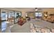 Open living room with ceiling fan, light color walls, carpet floor, and sliding door to the outside at 701 Baltusrol Way, Sun City Center, FL 33573