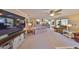 Spacious living room featuring open floor plan to kitchen, carpet floor, light color walls, and media center at 701 Baltusrol Way, Sun City Center, FL 33573