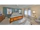 Comfortable main bedroom with neutral carpet, blue accent wall, ceiling fan, and abundant natural light at 701 Baltusrol Way, Sun City Center, FL 33573