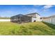 Grassy backyard featuring a screened-in patio with outdoor seating and barbecue grill at 7112 Samuel Ivy Dr, Tampa, FL 33619