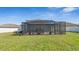 Large backyard featuring a screened-in patio, lounge seating, and green grass at 7112 Samuel Ivy Dr, Tampa, FL 33619