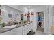Bright bathroom featuring double sinks, granite counters, and easy access to a walk-in closet at 7112 Samuel Ivy Dr, Tampa, FL 33619