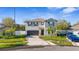Two-story home with neat landscaping, a two-car garage, and a cozy entrance, complemented by green lawns and some parked vehicles at 7112 Samuel Ivy Dr, Tampa, FL 33619