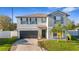 Charming two-story home featuring a well-manicured lawn, mature palms, a two-car garage, and a welcoming front entrance at 7112 Samuel Ivy Dr, Tampa, FL 33619