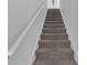 Carpeted staircase featuring a wooden handrail and neutral tones leading to upper levels at 7112 Samuel Ivy Dr, Tampa, FL 33619