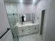 Bright bathroom offers a double sink vanity, frameless mirrors, tiled floor and glass shower at 8204 Chimney Rock Dr, Webster, FL 33597