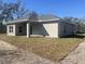 This is a gray stucco-sided home with a covered entrance and concrete porch sitting on a brown grassy lot at 8204 Chimney Rock Dr, Webster, FL 33597