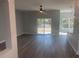 Bright living room features wood-look floors, ceiling fan and sliding glass doors leading to the outdoors at 8204 Chimney Rock Dr, Webster, FL 33597