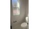 Clean powder room features a toilet, window, and stylish hardware at 8204 Chimney Rock Dr, Webster, FL 33597