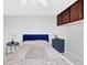 Bright bedroom featuring a blue headboard, overhead storage cabinets and bedside table at 851 Bayway Blvd # 904, Clearwater Beach, FL 33767