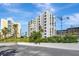 Exterior view of condo buildings with modern architecture, manicured lawns, and a construction crane in the background at 851 Bayway Blvd # 904, Clearwater Beach, FL 33767