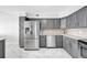 Well-equipped kitchen featuring stainless steel appliances, gray cabinetry, and elegant marble flooring at 851 Bayway Blvd # 904, Clearwater Beach, FL 33767