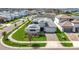 Aerial view of a gray home with a paver driveway and well-manicured landscaping at 8721 Drummer Plank Dr, Wesley Chapel, FL 33545