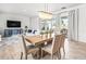 Bright dining room features a modern chandelier and sliding glass doors leading to the pool area at 8721 Drummer Plank Dr, Wesley Chapel, FL 33545