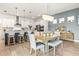 Open-concept dining area boasts a stylish chandelier and a view of the well-equipped kitchen with island seating at 8721 Drummer Plank Dr, Wesley Chapel, FL 33545