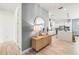 Beautiful entryway featuring wood flooring, decorative mirror, cabinet, and open floor plan into the kitchen at 8721 Drummer Plank Dr, Wesley Chapel, FL 33545