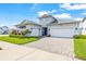 Beautiful two-story home featuring a three-car garage, lush landscaping, and a welcoming entrance at 8721 Drummer Plank Dr, Wesley Chapel, FL 33545