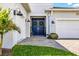 Close-up of the front entrance with double doors, brick pathway, well-manicured lawn and shrubs at 8721 Drummer Plank Dr, Wesley Chapel, FL 33545