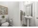 Tastefully designed half bathroom features a pedestal sink and contemporary decor at 8721 Drummer Plank Dr, Wesley Chapel, FL 33545