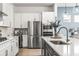 Sleek kitchen featuring stainless steel appliances, white cabinets, and a large island with seating at 8721 Drummer Plank Dr, Wesley Chapel, FL 33545