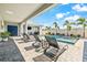 Relaxing outdoor lounge area including four lounge chairs and a view of the pool and landscaped backyard at 8721 Drummer Plank Dr, Wesley Chapel, FL 33545