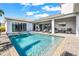 Gorgeous swimming pool with a sun shelf, surrounded by a patio, lounge chairs and covered outdoor space at 8721 Drummer Plank Dr, Wesley Chapel, FL 33545