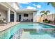 Stunning swimming pool and spa area with a covered outdoor living space with a fireplace at 8721 Drummer Plank Dr, Wesley Chapel, FL 33545