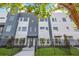 Modern townhome with gray and white facade, black iron fence, and manicured lawn at 879 6Th S Ave, St Petersburg, FL 33701