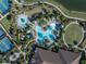 Aerial view of community pools with landscaping, seating, tennis courts, and a pond at 10446 Highland Park Pl, Palmetto, FL 34221