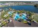 An aerial view of a community pool with a variety of water features surrounded by palm trees at 10446 Highland Park Pl, Palmetto, FL 34221