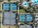 Aerial view of tennis and pickleball courts adjacent to the pool, lounge area, and a walking path at 10446 Highland Park Pl, Palmetto, FL 34221
