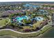 Aerial view of community amenities including a large pool and clubhouse, lush landscaping, and lake views at 10446 Highland Park Pl, Palmetto, FL 34221