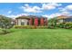 Well-manicured backyard featuring a lush lawn, mature landscaping, and a screened-in patio for outdoor living at 10446 Highland Park Pl, Palmetto, FL 34221