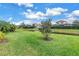 Scenic backyard view featuring a serene pond, lush green grass, and meticulously maintained landscaping at 10446 Highland Park Pl, Palmetto, FL 34221