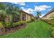 Well-manicured lawn with tropical landscaping and covered lanai at 10446 Highland Park Pl, Palmetto, FL 34221