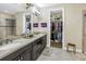 Elegant bathroom boasts a dual sink vanity, walk-in closet, and glass enclosed shower at 10446 Highland Park Pl, Palmetto, FL 34221