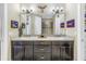 Bathroom with double vanity, granite countertops, large mirror, and decorative lighting fixtures at 10446 Highland Park Pl, Palmetto, FL 34221