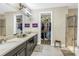 Bright primary bathroom features dual sinks, a walk-in closet and walk-in shower with glass door at 10446 Highland Park Pl, Palmetto, FL 34221
