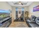Bright and airy exercise room features a ceiling fan, exercise bike, TV, and comfortable seating at 10446 Highland Park Pl, Palmetto, FL 34221