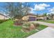 Charming home with a brick paver driveway, mature landscaping, and well-maintained lawn at 10446 Highland Park Pl, Palmetto, FL 34221
