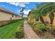 Beautiful landscaping with a brick path to the front, the grass is nicely trimmed, and a palm tree at 10446 Highland Park Pl, Palmetto, FL 34221