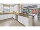 Bright kitchen featuring white cabinetry, granite countertops, and an open view to the outdoor living space at 10446 Highland Park Pl, Palmetto, FL 34221