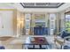 Open living room with coffered ceiling, neutral walls, windows, and sliding doors to patio at 10446 Highland Park Pl, Palmetto, FL 34221