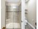 Shower with glass door, tiled walls, shower seat, and decorative accent tile at 10446 Highland Park Pl, Palmetto, FL 34221