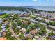 Beautiful aerial view of a neighborhood with a variety of homes, lush trees, and a glimpse of the nearby bay at 1180 Eden Isle Ne Blvd, St Petersburg, FL 33704